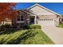 Charming single-Gathering home with a stone facade, a well-manicured lawn, and a two-car garage at 23941 E Whitaker Dr, Aurora, CO 80016