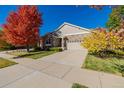 Beautiful home showcasing mature trees in vibrant fall colors, enhancing its curb appeal at 23941 E Whitaker Dr, Aurora, CO 80016