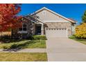 Charming single-story home with stone accents, a well-maintained lawn, and colorful autumn foliage at 23941 E Whitaker Dr, Aurora, CO 80016