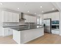 Bright kitchen boasts stainless steel appliances, white cabinets, and a spacious center island at 13765 Emerald Lake St, Parker, CO 80138