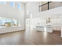 Open concept living area with large windows, wood floors, a kitchen and a second story view at 13765 Emerald Lake St, Parker, CO 80138