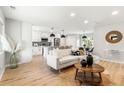 Bright, open-concept living room with modern decor, island with pendant lighting and stainless appliances at 3061 S Glencoe St, Denver, CO 80222