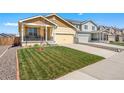 Beautiful single-Gathering home with a well-maintained lawn and a cozy front porch at 47385 Lily Ave, Bennett, CO 80102