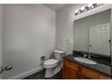 Cozy half-bath with granite countertop, a white toilet, and new vanity at 12783 Ivy St, Thornton, CO 80602