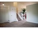 Bright entryway with carpet, coat closet, staircase, and view into the dining area at 10534 Ursula St, Commerce City, CO 80022