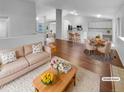 Bright, open-concept living space with hardwood floors flowing to a dining area and kitchen at 5236 S Liverpool Way, Centennial, CO 80015