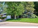 Well-maintained home exterior with mature trees and landscaping on a green lawn at 4338 S Alton St, Greenwood Village, CO 80111