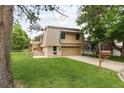 Two-story home with a well-maintained lawn and mature trees at 141 S Upham Ct, Lakewood, CO 80226
