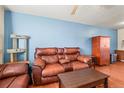 Comfortable living room featuring hardwood floors, a ceiling fan, and a modern cat tree at 221 Jackson Ave, Firestone, CO 80520