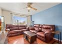 Inviting living room with warm hardwood floors and plush leather sofas at 221 Jackson Ave, Firestone, CO 80520