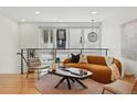 Open loft living area with hardwood floors, modern railing, comfortable seating and natural light at 4539 Tennyson St # 105, Denver, CO 80212