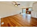 Spacious living room with hardwood floors, ceiling fan, and seamless transition into dining area at 4312 S Xenon St, Morrison, CO 80465