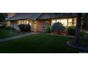 Well-manicured front yard with landscape lighting and green grass, leading to the home's entrance at 2250 N Monaco Pkwy, Denver, CO 80207