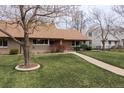Well-kept home with a lush green lawn and mature trees in a quiet neighborhood at 2250 N Monaco Pkwy, Denver, CO 80207