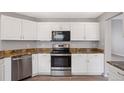 Bright kitchen with stainless steel appliances, white cabinets and granite countertops at 20481 E Mansfield Pl, Aurora, CO 80013