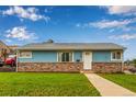 Charming single-story home featuring stone accents, a well-manicured lawn, and a classic white front door at 5001 W Nevada Pl, Denver, CO 80219