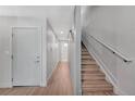 Bright hallway featuring wood floors, a staircase with white railing, and a white door at 2893 W 10Th Ave, Denver, CO 80204