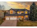 Charming two-story home with a three car garage, manicured lawn, and inviting covered front porch at 7128 Orchard St, Arvada, CO 80007