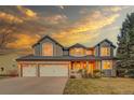 Charming two-story home with a three car garage, manicured lawn, and inviting covered front porch at 7128 Orchard St, Arvada, CO 80007