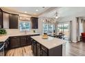 Modern kitchen with stainless steel appliances, dark cabinets, a quartz island, and stylish pendant lighting at 7933 Florado St, Denver, CO 80221