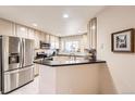Bright kitchen with stainless steel appliances, white cabinetry and stone countertops at 7774 S Biloxi Way, Aurora, CO 80016