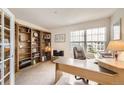 Spacious office area with built-in shelves, large windows, and a comfortable workspace at 7774 S Biloxi Way, Aurora, CO 80016