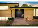 Inviting front entrance features a brick landing, dual doors, and a cozy chair at sunset at 85 S Flower St, Lakewood, CO 80226
