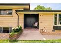 Inviting front entrance features a brick landing, dual doors, and a cozy chair at 85 S Flower St, Lakewood, CO 80226