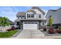Beautiful two-story home features a stone facade, two-car garage, and well-manicured lawn at 7166 S Vandriver Way, Aurora, CO 80016