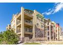 Low-angle view of the apartment building showcasing its architectural details, multiple balconies, and colorful accents at 1162 Rockhurst Dr # 404, Highlands Ranch, CO 80129