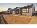 Newly landscaped backyard with fresh dirt and straw, featuring a covered patio area and a privacy fence at 11490 Autumn Moon St, Littleton, CO 80125