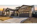 Beautiful home with a two-car garage, stone accents, neutral colors, and freshly laid sod in the front yard at 11490 Autumn Moon St, Littleton, CO 80125