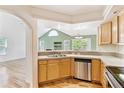 Eat-in kitchen featuring wooden cabinetry and stainless steel appliances overlooking the living room at 2330 S Salem Cir, Aurora, CO 80014
