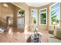 Sun-filled foyer with hardwood floors, large windows, and an arched doorway at 10831 Eagle Crest Ln, Parker, CO 80138