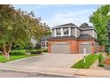 Lovely two-story home with a brick and siding exterior, lush lawn, and a spacious driveway at 930 W Dry Creek Rd, Littleton, CO 80120