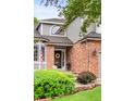 Charming home featuring a brick facade and a welcoming front door with decorative wreath at 930 W Dry Creek Rd, Littleton, CO 80120