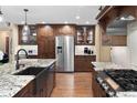 A gourmet kitchen featuring granite countertops, stainless steel appliances, and custom wood cabinetry at 930 W Dry Creek Rd, Littleton, CO 80120