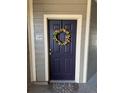 Close-up of the front door, adorned with a decorative wreath at 17346 Nature Walk Trail Trl # 105, Parker, CO 80134