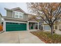 Two-story house with green garage door and landscaping; view of neighbor's house at 2389 Quartz St, Castle Rock, CO 80109