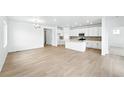 Bright, open-concept living room and kitchen with hardwood floors and modern lighting fixtures at 39732 Penn Rd, Elizabeth, CO 80107