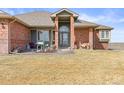 Charming front entrance with decorative pillars and lush green lawn at 22990 County Road 30, Hudson, CO 80642