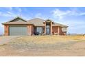 Inviting single-story brick home with a well-maintained lawn and attached garage at 22990 County Road 30, Hudson, CO 80642