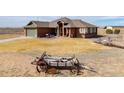 Landscaped front yard featuring unique western wagon wheel art and green lawn at 22990 County Road 30, Hudson, CO 80642