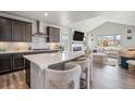 Open-concept kitchen with island seating, flowing into a comfortable living space at 4532 Dewey Ln, Brighton, CO 80603