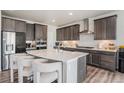 Modern kitchen featuring a large island with seating and stylish gray cabinets at 4532 Dewey Ln, Brighton, CO 80603