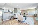 Bright open living room shows wood floors, modern decor, and a partial view of the kitchen and dining area at 507 S Pontiac Way, Denver, CO 80224