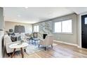 Sunlit living room has wood floors, modern fireplace, and neutral colors, creating a warm and inviting atmosphere at 507 S Pontiac Way, Denver, CO 80224