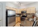 Efficient kitchen featuring stainless steel appliances, granite countertops, and ample cabinets at 4733 Flower St, Wheat Ridge, CO 80033