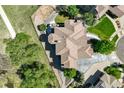Aerial view of a luxurious home showcasing its unique roof design, landscaping, and surrounding neighborhood at 24031 E Hinsdale Pl, Aurora, CO 80016