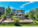 Expansive backyard with a terraced layout, stone retaining walls, and lush greenery at 24031 E Hinsdale Pl, Aurora, CO 80016